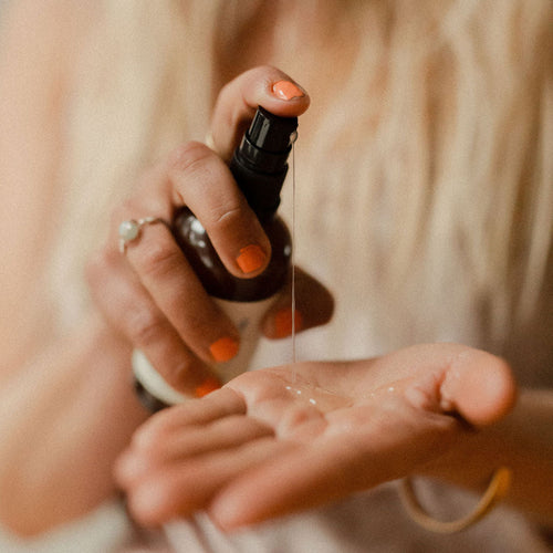 Person holding a bottle over their palm for waterbased lube no fragrance